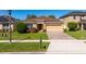 Attractive one-story home boasts a well-kept lawn, tan exterior and a two-car garage at 4605 Kalispell Rd, Kissimmee, FL 34758