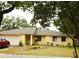 Charming single-story home with mature trees, a two-car garage, and tidy front yard landscaping at 4790 Point Look Out Rd, Orlando, FL 32808