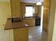 An eat-in kitchen with wood cabinets, neutral countertops, a tile backsplash, and stainless steel appliances at 4790 Point Look Out Rd, Orlando, FL 32808