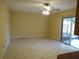 A bright living room with neutral walls, tile flooring, ceiling fan, and sliding glass doors leading to the backyard at 4790 Point Look Out Rd, Orlando, FL 32808