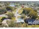 Aerial view of a quiet neighborhood, featuring lush trees, a community lake, and well-maintained homes at 4900 Kempston Dr, Orlando, FL 32812