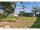 Large backyard featuring a covered patio, lush greenery, and mature trees at 4900 Kempston Dr, Orlando, FL 32812