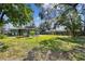 A serene backyard oasis featuring a lush lawn, mature trees, and a private setting, offering a peaceful retreat at 4900 Kempston Dr, Orlando, FL 32812