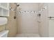 Modern bathroom shower featuring neutral tile design, updated shower head, and built-in shelving at 4900 Kempston Dr, Orlando, FL 32812