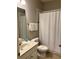 Clean bathroom featuring a single sink vanity, a toilet, and a shower with a white curtain at 5356 Oakbourne Ave, Davenport, FL 33837