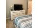 Well-lit bedroom featuring a dresser with TV and a comfortable bed with soft bedding at 5356 Oakbourne Ave, Davenport, FL 33837