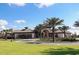 Community clubhouse with a terracotta roof, lush landscaping, and circular driveway entrance at 5356 Oakbourne Ave, Davenport, FL 33837