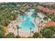 Aerial view of the stunning community pool featuring winding walkways, tropical landscaping, and ample lounge chairs at 5356 Oakbourne Ave, Davenport, FL 33837