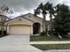 Charming single-story home with a terra cotta tile roof, well-manicured lawn, and a two-car garage at 5356 Oakbourne Ave, Davenport, FL 33837