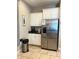 Compact kitchenette with stainless steel refrigerator, granite countertop, and storage cabinets at 5356 Oakbourne Ave, Davenport, FL 33837