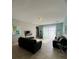 Cozy living room with comfortable seating, tile flooring, and natural light from sheer curtains at 5356 Oakbourne Ave, Davenport, FL 33837