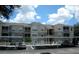 Exterior view of condo building, showcasing the covered parking, tan color, and second-story facade at 586 Brantley Terrace Way # 201, Altamonte Springs, FL 32714