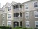 Exterior view of a multi-story condo building with stucco siding and screened balconies at 586 Brantley Terrace Way # 201, Altamonte Springs, FL 32714