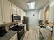 Well-lit kitchen featuring white cabinets, granite countertops, stainless steel appliances, and modern flooring at 586 Brantley Terrace Way # 201, Altamonte Springs, FL 32714