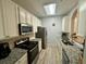 Well-lit kitchen featuring white cabinets, granite countertops, stainless steel appliances, and modern flooring at 586 Brantley Terrace Way # 201, Altamonte Springs, FL 32714