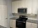Kitchen area featuring stainless steel appliances, granite counters, and white cabinetry at 586 Brantley Terrace Way # 201, Altamonte Springs, FL 32714