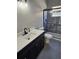 Bathroom with dark vanity, solid surface countertop, black faucet, and shower-tub combo at 703 Pine Shores Cir, New Smyrna Beach, FL 32168