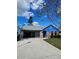 Charming single-story home featuring blue siding, brick accents, and a spacious driveway on a sunny day at 703 Pine Shores Cir, New Smyrna Beach, FL 32168