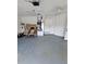 Spacious garage with painted concrete floor, storage cabinets and a ceiling fan at 703 Pine Shores Cir, New Smyrna Beach, FL 32168