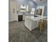 Bright kitchen features white cabinets, an island with cooktop, quartz counters and stainless-steel dishwasher at 703 Pine Shores Cir, New Smyrna Beach, FL 32168