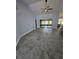 Bright living room featuring tile flooring, neutral walls, and a view of the sliding glass door to lanai at 703 Pine Shores Cir, New Smyrna Beach, FL 32168