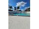 Sparkling community pool with lounge chairs, surrounded by a white fence and sunny skies at 703 Pine Shores Cir, New Smyrna Beach, FL 32168