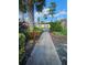 A walkway flanked by landscaped plants and flowers at 703 Pine Shores Cir, New Smyrna Beach, FL 32168