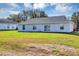 Spacious backyard with lush green grass, a single story home, and windows at 7139 Se 122Nd Ln, Belleview, FL 34420