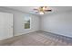 Bedroom featuring gray carpet, a ceiling fan, and a window providing natural light at 7139 Se 122Nd Ln, Belleview, FL 34420