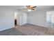 Bedroom with gray carpet, a ceiling fan and bathroom and closet doors at 7139 Se 122Nd Ln, Belleview, FL 34420