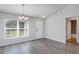 Bright dining room with modern chandelier, neutral walls, and wood-look floors at 7139 Se 122Nd Ln, Belleview, FL 34420