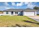 Charming single-story home with a well-manicured lawn, neutral exterior paint, and a two-car garage at 7139 Se 122Nd Ln, Belleview, FL 34420