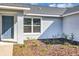 A close-up view of the entry door, window, and landscape of the front exterior of the home at 7139 Se 122Nd Ln, Belleview, FL 34420