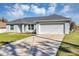 Charming single-story home with a well-manicured lawn, neutral exterior paint, and a two-car garage at 7139 Se 122Nd Ln, Belleview, FL 34420