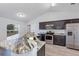Modern kitchen featuring granite countertops, stainless steel appliances, and dark cabinetry at 7139 Se 122Nd Ln, Belleview, FL 34420