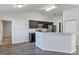 Well-lit kitchen with stainless steel appliances, dark cabinets, and granite breakfast bar at 7139 Se 122Nd Ln, Belleview, FL 34420