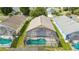 Aerial view of homes featuring screened-in pools and well-maintained yards in a quiet neighborhood at 8095 Indian Creek Blvd, Kissimmee, FL 34747
