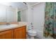 Bright bathroom featuring a shower-tub combination, vanity with sink, and floral shower curtain at 8095 Indian Creek Blvd, Kissimmee, FL 34747