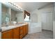 Bathroom featuring double sinks, a tub, and a walk-in shower, with ample cabinet space at 8095 Indian Creek Blvd, Kissimmee, FL 34747