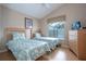 Bright bedroom with two twin beds, a ceiling fan, and a window offering natural light at 8095 Indian Creek Blvd, Kissimmee, FL 34747