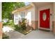 Inviting front entrance with a vibrant red door, brick accents, and manicured landscaping at 8095 Indian Creek Blvd, Kissimmee, FL 34747