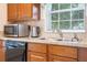 Well-maintained kitchen with stainless steel microwave, double basin sink, and wood cabinets at 8095 Indian Creek Blvd, Kissimmee, FL 34747