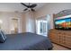 Main bedroom with access to the patio, featuring a tv on a dresser and a ceiling fan at 8095 Indian Creek Blvd, Kissimmee, FL 34747