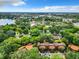 Expansive aerial view of complex, lake, and city, all surrounded by a canopy of mature trees at 976 E Michigan St # A, Orlando, FL 32806