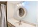 This bathroom features a white sink with chrome faucet, a round mirror and three-light vanity fixture at 976 E Michigan St # A, Orlando, FL 32806