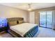 Cozy bedroom with a tufted headboard, soft carpet, and a sliding glass door to the outside at 976 E Michigan St # A, Orlando, FL 32806