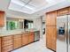 Modern kitchen with stainless steel appliances, wood cabinets, and granite countertops at 976 E Michigan St # A, Orlando, FL 32806