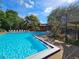 Community pool featuring ample seating, lush landscaping, and a spiral staircase to upper floors at 976 E Michigan St # A, Orlando, FL 32806