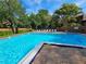 Community pool surrounded by lush landscaping and lounge chairs at 976 E Michigan St # A, Orlando, FL 32806