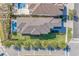 An aerial view of a well-maintained home with a lush yard, sleek roof, pool and palm tree lined street at 985 Jack Nicklaus Ct, Kissimmee, FL 34747